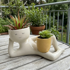Blumentopf als liegende Figur in glänzender Keramikoptik