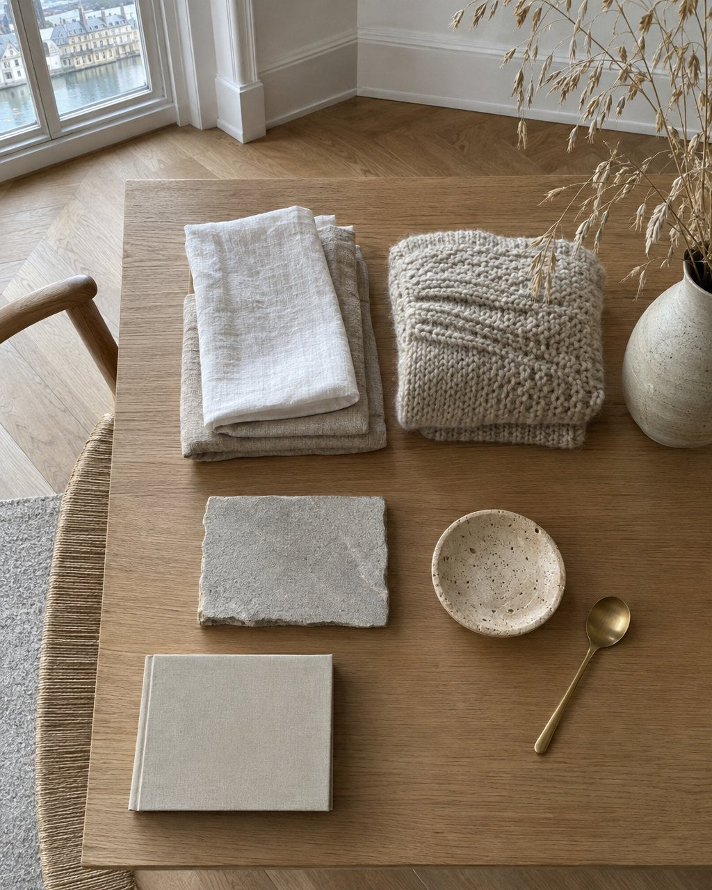 Materialstillleben mit Leinen, Wolle, Sandstein, Travertin und Messing auf Eichenholz